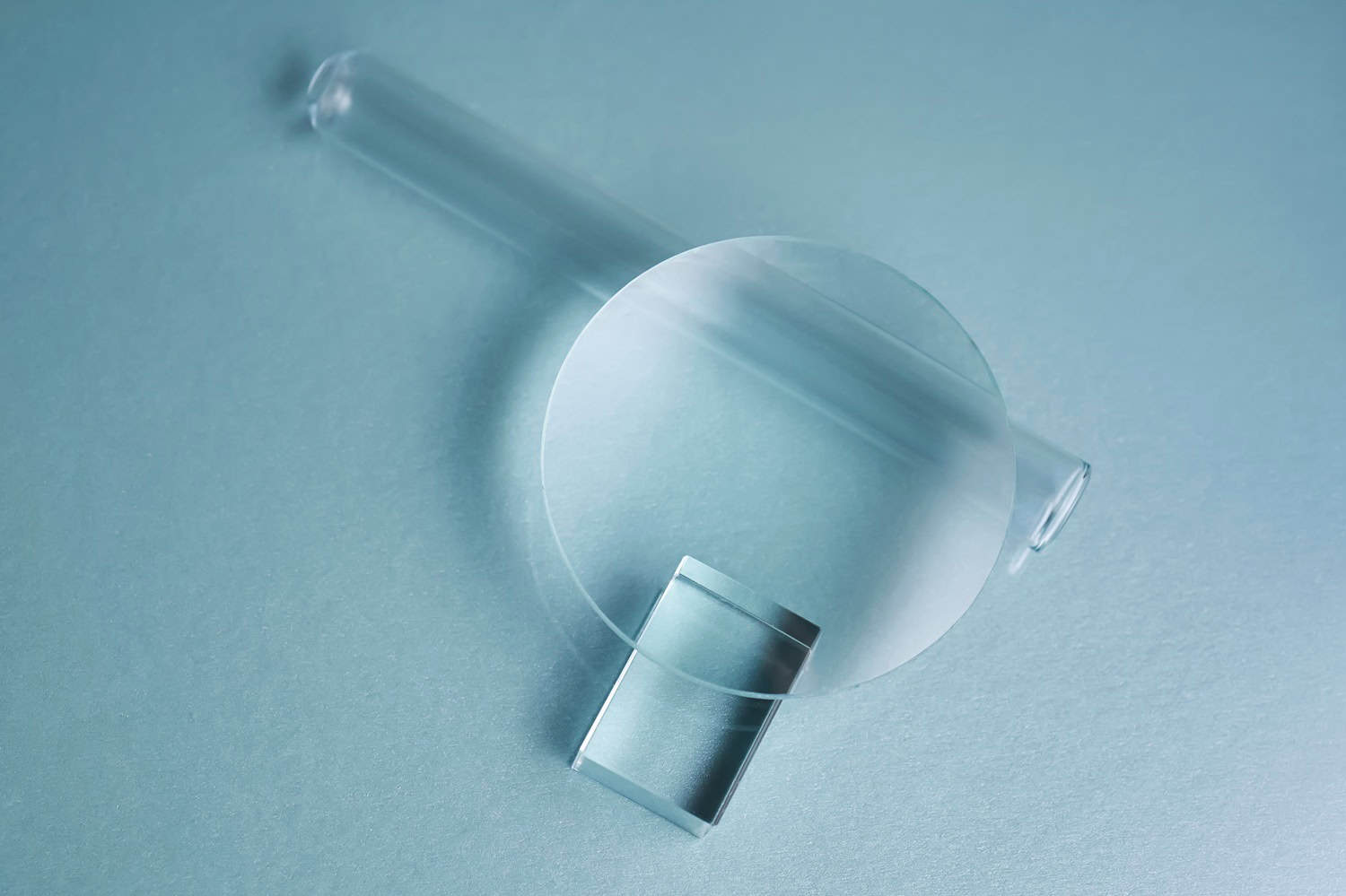 Glass objects and prisms on a blue background.