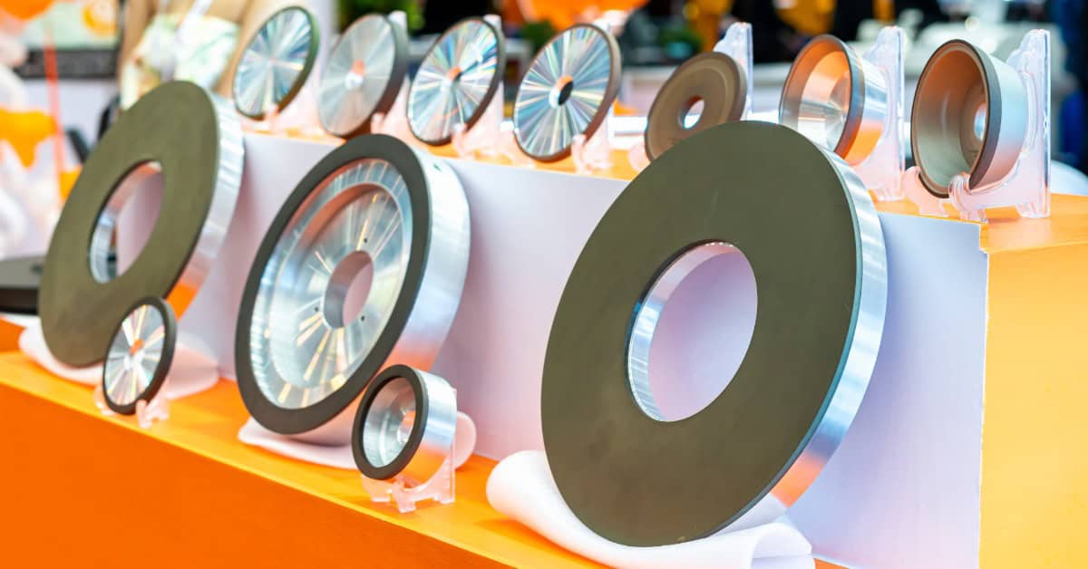 Various sizes and types of grinding wheels sit on an orange display. They are propped up with plastic stands.